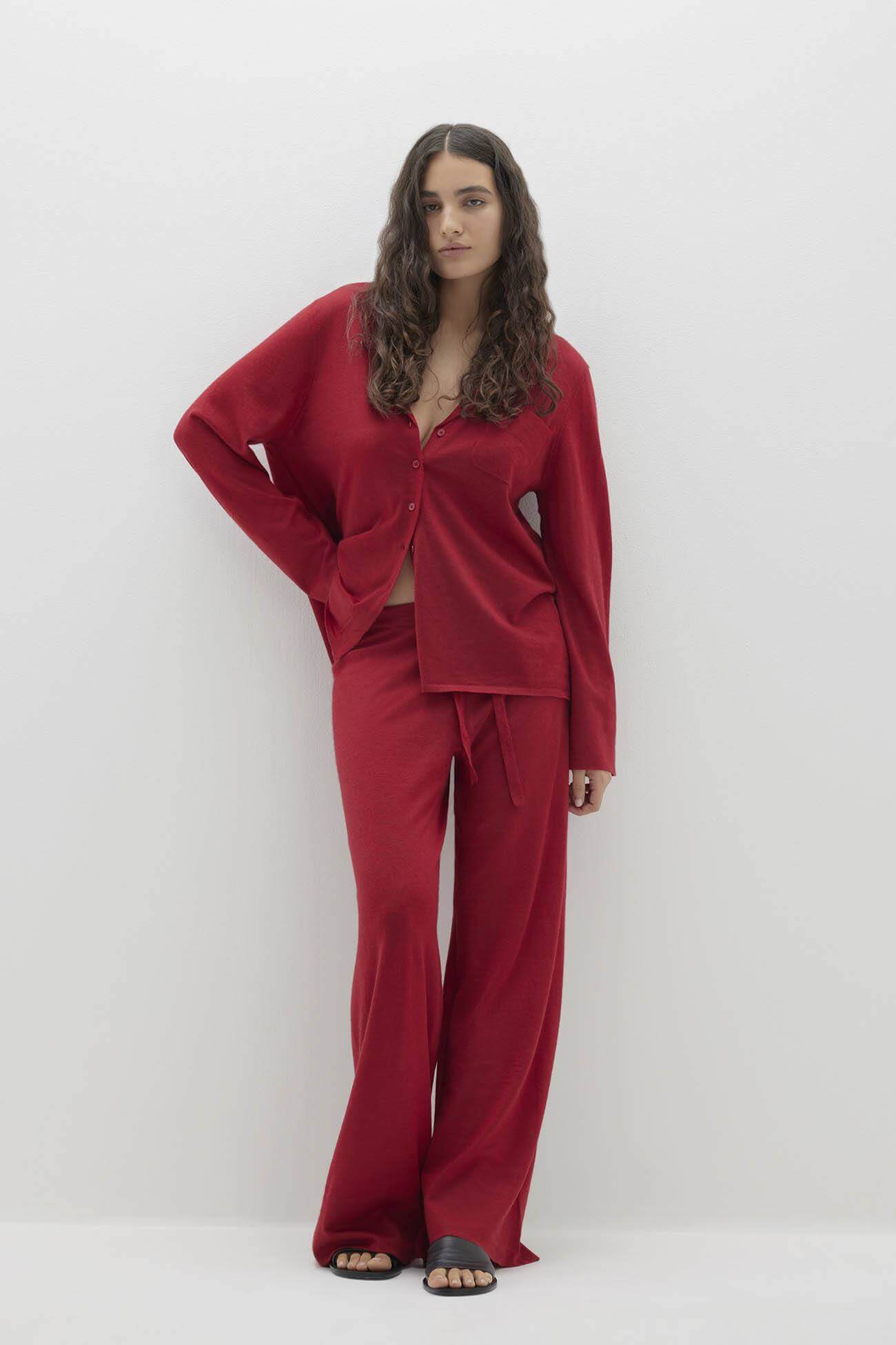 A model wearing red sleepwear featuring a long-sleeve top and wide-leg pants.