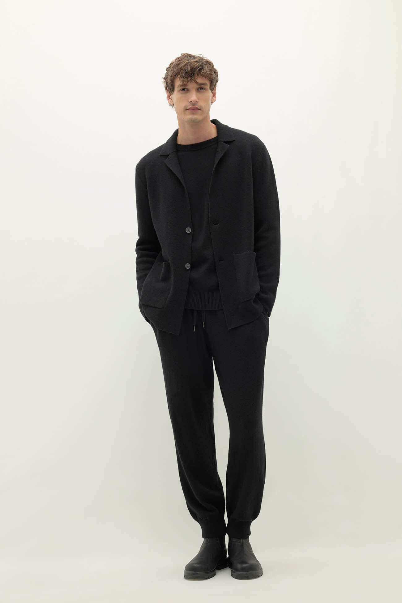 Our Men Wear: Model showcasing a stylish all-black outfit with a casual blazer and joggers.